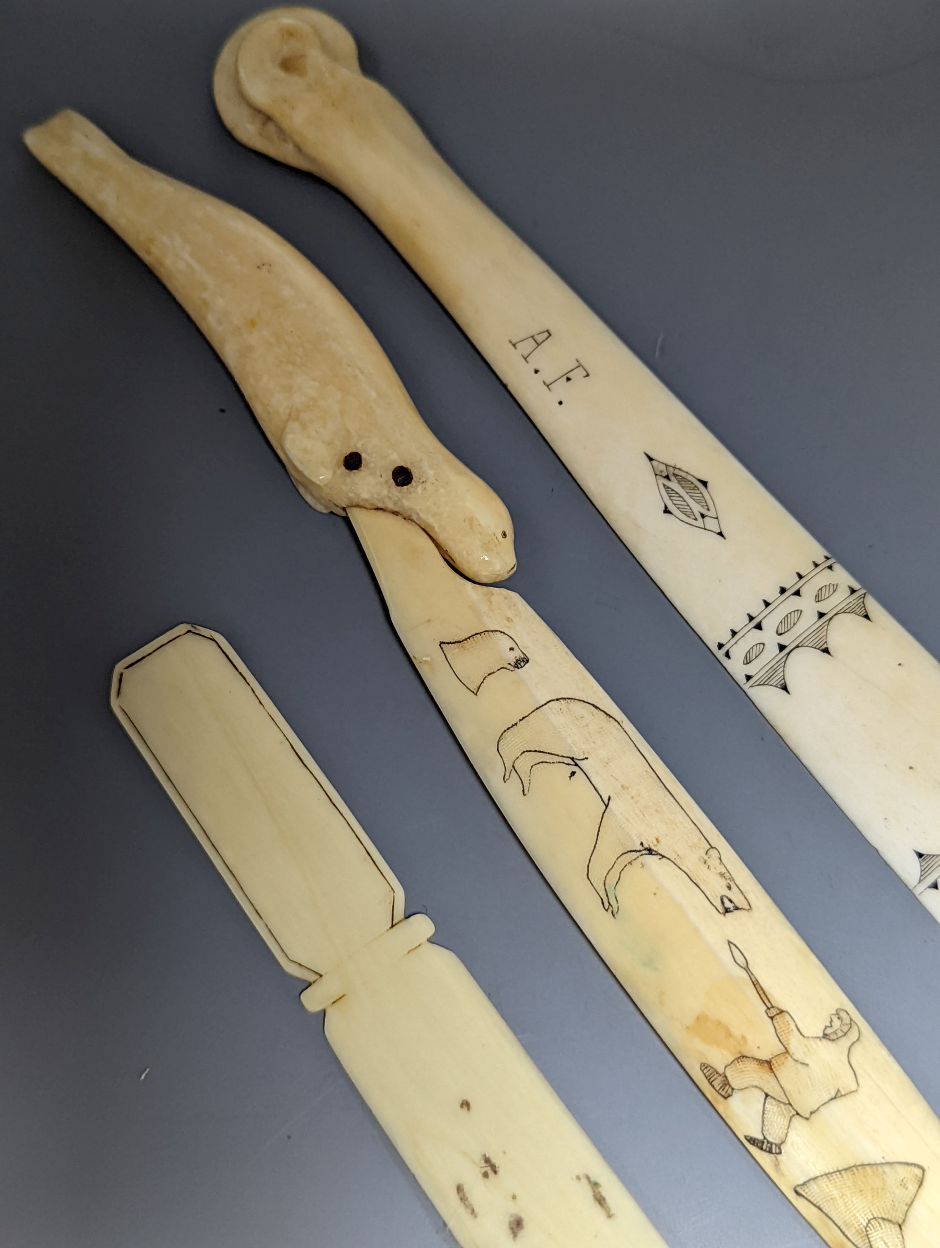 A 19th century Scrimshaw seal paperknife, 22cm., and two other engraved bone paperknives